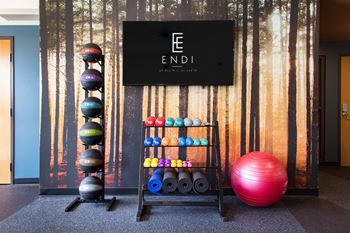 A gym with a sign that says "ENDI" and exercise balls of various colors.
